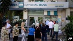 Warga di Athena antri untuk mengambil uang di mesin ATM di sebuah bank (foto: dok). Yunani dan kreditor sedang membahas dana talangan untuk mengatasi kredit macet di bank-bank Yunani.