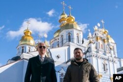Presiden Joe Biden berjalan bersama Presiden Ukraina Volodymyr Zelenskyy di Katedral Kubah Emas St. Michael dalam kunjungan mendadak di Kyiv, Senin, 20 Februari 2023. (Foto AP/Evan Vucci)