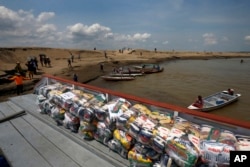 FILE - Packages with food for riverside communities due to the ongoing drought sit on a dock, in Careiro da Varzea, Amazonas state, Brazil on October 24, 2023. (AP Photo/Edmar Barros, File)