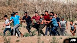 រូបឯកសារ៖ បាតុករប៉ាឡេស្ទីនលើកបុរសរងរបួសម្នាក់អំឡុងពេលប៉ះទង្គិចគ្នានៅក្នុងបាតុកម្មមួយ​នៅតំបន់ Gaza Strip កាលពីថ្ងៃទី០៦ ខែកញ្ញា ឆ្នាំ២០១៩។ 