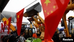 Bendera China terlihat di depan kendaraan konstruksi selama China Import and Export Fair, juga dikenal sebagai Canton Fair, di selatan kota Guangzhou, China 16 April 2018. (Foto: REUTERS/Tyrone Siu)
