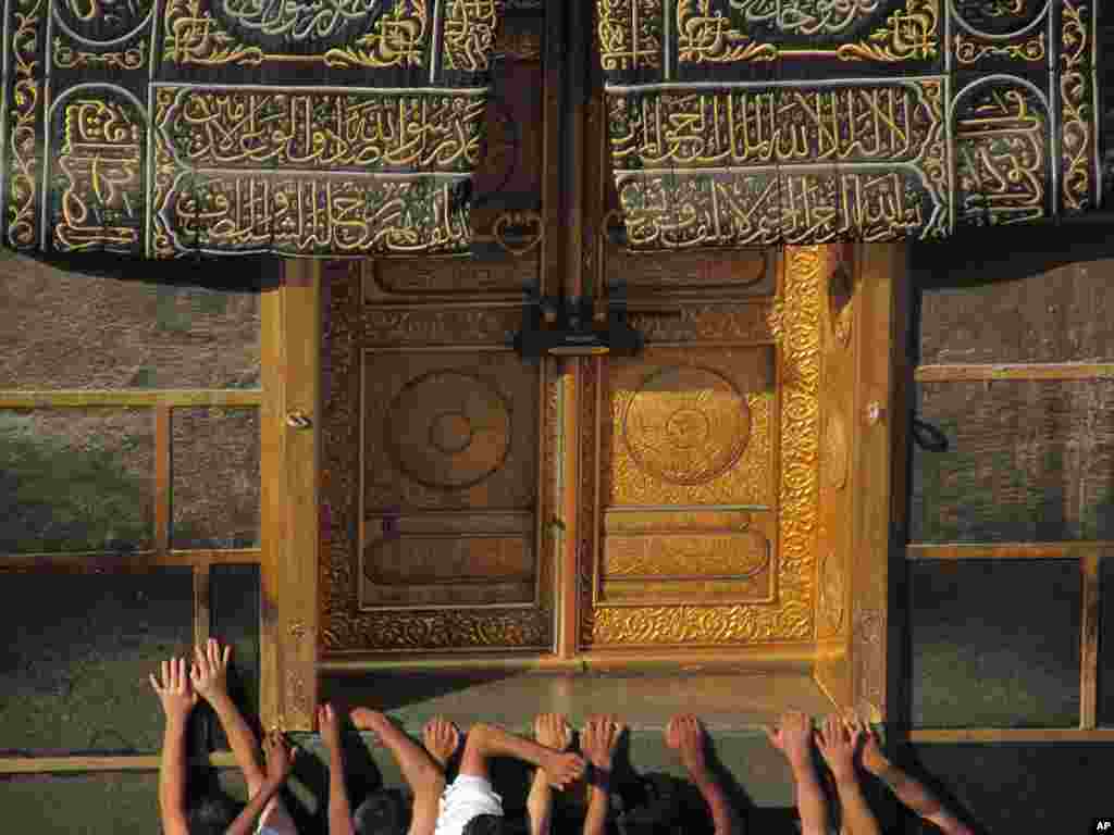 Muslim pilgrims pray at the door of the Kabaa in the holy city of Mecca, Saudi Arabia, Oct. 13, 2013.