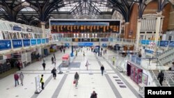A man pushes his bicycle across the concourse of Liverpool Street railway station during morning rush hour, London, Britain, June 3, 2020. 