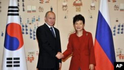 Presiden Korea Selatan Park Geun-hye berjabat tangan dengan Presiden Rusia Vladimir Putin (kiri) di Kantor Kepresidenan "Gedung Biru" di Seoul, Korea Selatan (13/11).
