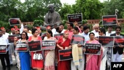 Members of the parliament (MP) from Samajwadi Party (SP), Dravida Munnetra Kazhagam (DMK) and Trinamool Congress (TMC) parties display placards during a protest calling for action in a rape case in Uttar Pradesh, in New Delhi on July 30, 2019.