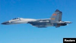 日本防卫省2014年3月24日公布的照片显示中国苏-27战机飞越东中国海上空。
