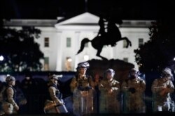 A line of DC National Guard members stand in Lafayette Park as demonstrators gather to protest the death of George Floyd, June 2, 2020, near the White House in Washington.