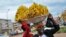 FILE - Women sell bananas on a street in Kampala, Uganda, March 26, 2020. 