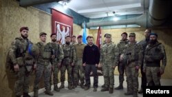 乌克兰总统办公室新闻处公布的照片显示乌克兰总统泽连斯基与乌克兰武装部队司令瑟尔斯基将军在苏梅地区与阵地上的乌克兰军人合影。(2024年10月4日).