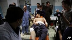 An injured man is brought into a hospital following deadly blasts at a wrestling club in Kabul, Afghanistan, Sept. 5, 2018.