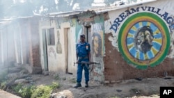 Un policier embusqué attend des manifestants alors que des grenades lacrymogènes ont été lancées, dans le district de Cibitoke, près de Bujumbura, le 29 mai 2015