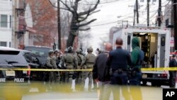 Police officers gather nearby the scene following reports of gunfire, in Jersey City, N.J., Dec. 10, 2019.