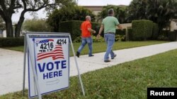 Para calon pemilih berjalan menuju TPS untuk mengikuti pemilihan pendahuluan di Boca Raton, Florida (15/3).