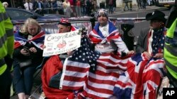Royal fans John Loughry, second right, and Terry Hutt, second left, show off their placards outside Windsor Castle, in Windsor, England, May 16, 2018. 