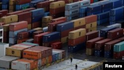 Para pekerja di antara tumpukan peti kemas yang sedang diturunkan dari sebuah kapal di pelabuhan Liverpool, utara Inggris, 9 Desember 2016.