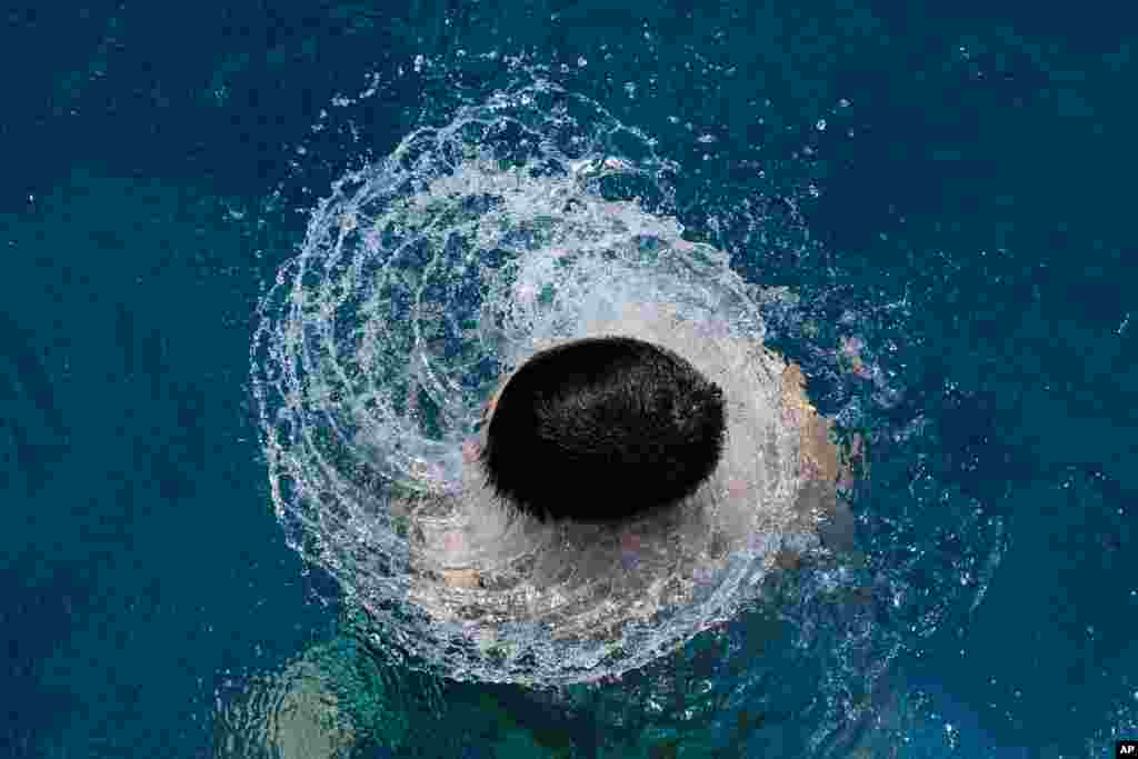 Seorang anak laki-laki muncul dari menyelam di sebuah kolam renang umum di Berlin, Jerman.