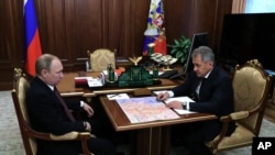 Russian President Vladimir Putin, left, listens to Defense Minister Sergei Shoigu during a meeting in the Kremlin, in Moscow, Russia, Friday, Dec. 23, 2016.