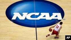 FILE - Wisconsin's Traevon Jackson dribbles past the NCAA logo during practice at the NCAA men's college basketball tournament in Anaheim, Calif., March 26, 2014.
