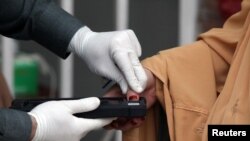 A woman gets her thumb verification to receive cash from a counter of Ehsaas Emergency Cash program, introduced by the government for vulnerable families due to the spread coronavirus disease (COVID-19), in Peshawar, Pakistan April 9, 2020. 