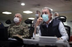 On June 15, 2020, Turkish Defense Minister Hulusi Akar, right, and Chief of Staff Gen. Yasar Guler monitor a military operation in Ankara. Turkey said it has airlifted troops for a cross-border ground operation against Kurdish militants in Iraq.