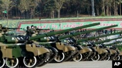 Tentara militer Myanmar memberikan hormat dari tank ketika melewati tempat perayaan kemerdekaan ke-67 di Naypyitaw, Myanmar, Minggu, 4 Januari 2015. (AP Photo/Khin Maung Win)