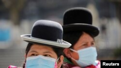 Aymara indigenous women wearing protective masks are seen at the Plaza Murillo during a celebration marking the 195th anniversary of Bolivia foundation at the presidential palace, amid the COVID-19 outbreak, in La Paz, Bolivia, Aug. 6, 2020.