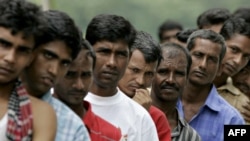 FILE - Bangladeshi migrant workers wait in line for food donated by a goodwill charity group for Christmas outside the Bangladeshi High Commission in Kuala Lumpur, Malaysia, Dec. 25, 2007.