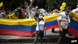 People wave the Colombian national flag during a demonstration in opposition to road blockades and violence, after a month of national protests, in Bogota, on May 30, 2021. 
