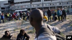 Migrants line up as they wait to be evacuated from a makeshift street camp, in Paris, France, July 7, 2017.