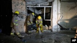 Petugas pemadam kebakaran Afghanistan menyemprotkan air ke lokasi ledakan bom bunuh diri di Kabul, Minggu (29/3).