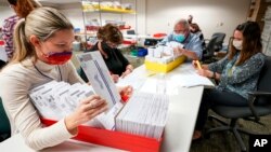 Lehigh County workers count ballots as vote counting in the general election continues, Thursday, Nov. 5, 2020, in Allentown, Pa. (AP Photo/Mary Altaffer)