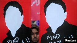 巴基斯坦示威者在拉合尔举行的一次抗议活动中手举活动人士拉扎·汗画像要求当局释放他。（2017年12月11日）