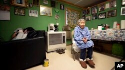 In this Monday, Jan. 20, 2020 image, Lizzie Chimiugak, right, looks on at her home in Toksook Bay, Alaska. Chimiugak, who turned 90 years old on Monday, is scheduled to be the first person counted in the 2020 U.S. Census on Tuesday. (AP Photo/Gregory Bull)
