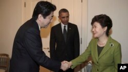 25일 네덜란드 헤이그에서 미-한-일 3국 정상회담에 앞서 박근혜 한국 대통령(왼쪽)과 아베 신조 일본 총리가 악수하고 있는 가운데, 바락 오바마 미국 대통령이 이를 지켜보고 있다.