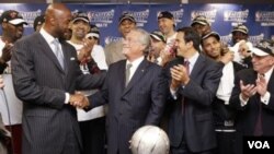 Alonzo Mourning, kiri, bersalaman dengan pemilik Miami Heat Micky Arison, sementara pelatih Erik Spoelstra tersenyum setelah Heat mengalahkan Chicago Bulls 83-80 di game 5 final Wilayah Timur NBA Kamis (26/5) di Chicago.