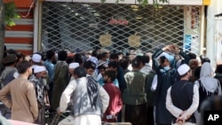 Afghans wait for hours to try to withdraw money, in front of Kabul Bank, in Kabul, Afghanistan, Saturday, Aug. 28, 2021. (AP Photo/Khwaja Tawfiq Sediqi)