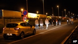 Sebuah mobil keamanan Eurotunnel mengikuti sebuah group migran di Calais, Perancis Utara, Rabu (29/7).