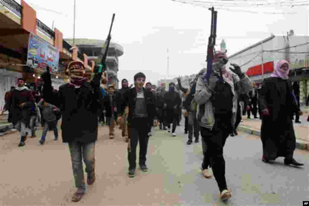 Mourners and Sunni gunmen chant slogans against Iraq&#39;s Shiite-led government during funeral of a man killed in clashes in Fallujah, Jan. 4, 2014.