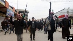 Warga menyerukan slogan-slogan anti pemerintah yang dikuasai kelompok Syiah di Irak dalam sebuah upacara pemakaman seorang pria yang tewas dalam bentrokan antara militan al-Qaida dan polisi di Fallujah (4/1). 