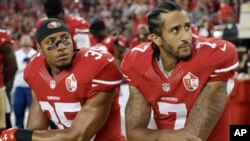 Pemain NFL klub San Francisco 49ers safety Eric Reid dan quarterback Colin Kaepernick (kanan) menolak berdiri saat dinyanyikan lagu kebangsaan AS (foto: dok).