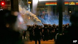 Polisi menembakkan gas air mata ke arah demonstran yang memprotes penembakan pria kulit hitam oleh polisi di Charlotte, North Carolina (21/9). (AP/Gerry Broome)