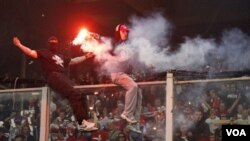 Pendukung Serbia menaiki pembatas untuk melempar petasan dan kembang api ke lapangan dalam pertandingan kualifikasi Euro 2012 grup C antara Italia dan Serbia di Genoa hari Selasa (12/10).