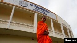 ព្រះសង្ឃ​មួយ​អង្គ​និមន្ត​ក្បែរ​សាលសវនាការ​សាលាក្តី​ខ្មែរ​ក្រហម​នៅ​ជាង​ក្រុង​ភ្នំពេញ។ (១៦ តុលា ២០១៣)