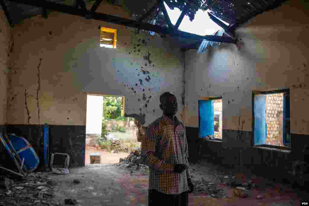 Head teacher Kuku Barnabas stands inside a building bombed earlier this year by Sudan’s government forces. He says 54 bombs landed on the school in one day, but the school is still operating. (Adam Bailes/VOA News)