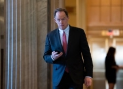 FILE - Sen. Pat Toomey returns from a break in the impeachment trial of President Donald Trump on charges of abuse of power and obstruction of Congress, at the Capitol in Washington, Feb. 3, 2020.