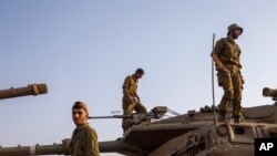 FILE - Israeli soldiers work on tanks in the Israeli controlled Golan Heights near the border with Syria, not far from Lebanon border, July 28, 2020. 