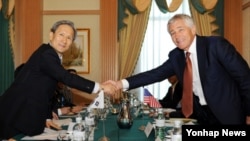 28일 브루나이 수도 반다르스리브가완에서 열린 제2차 아세안 확대 국방장관회의에 참가한 김관진 한국 국방장관(왼쪽)과 척 헤이글 미국 국방장관이 회담에앞서 악수하고 있다.