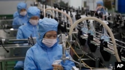 Pekerja Pabrik Sabun Ryongaksan membuat disinfektan di Pyongyang, Korea Utara, Kamis, 19 Maret 2020. (Foto: AP)