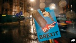 Kendaraan melintas poster anti-Brexit yang dipasang dekat gedung Parlemen di London, 29 Januari 2019. 