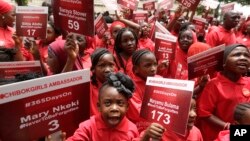 Young girls known as Chibok Ambassadors, carry names of the girls kidnapped last year in Chibok by Boko Haram militants at a rally in Abuja, April 14, 2015. (AP Photo/Sunday Alamba)